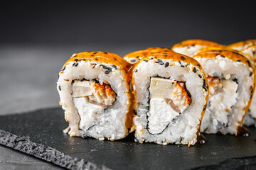 appetizing sushi roll california with eel tofu sesame and unagi cheese on a black stone plate