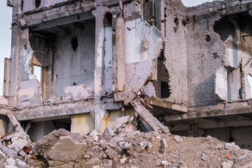 A pile of construction debris lies against the background of a large destroyed building. Selective focus.Background