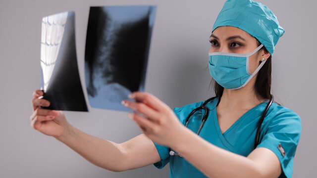 Female Doctor at hospital looks at X-rays - studio photography