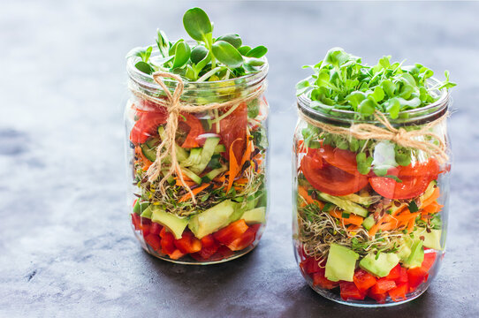 Vegetables salad in open jar Tomato, avocado,pepper, cucumber, micro greens Healthy food, diet, clean food and vegetarian concept