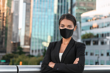 Asian business woman or real estate agent confident portrait wearing face mask for coronavirus prevention in urban city background.