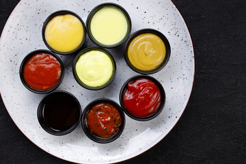 Assorted dips and sauces in bowls on plate