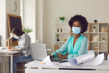 Return to workplace after coronavirus pandemic lockdown. Portrait of black woman in face mask...