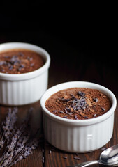 Chocolate vegan dessert - aquafaba mousse - egg free, non-dairy cocoa pudding or souffle decorated with lavender on dark moody background, closeup, vegan and vegetarian food concept