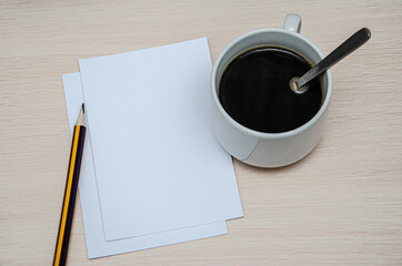 booklet, pencil and coffee cup on vintage wood background. Responsive design mockup.