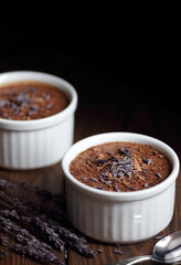 Chocolate vegan dessert - aquafaba mousse - egg free, non-dairy cocoa pudding or souffle decorated with lavender on dark moody background, closeup, vegan and vegetarian food concept