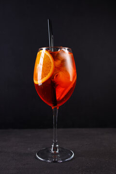 Glass of aperol spritz cocktail on black background