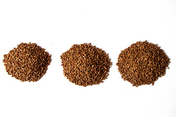 Three heap of dry buckwheat groats isolated on white background. Healthy product. Vegetarian food. Top view.