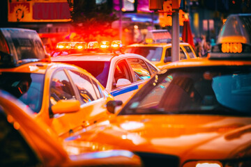 New York City Police patrol car flashing beacon siren lights in busy NYC traffic jam with yellow...