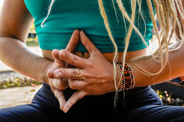 Caucasian woman's hands with dreadlocks in meditation posture