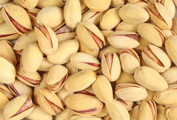 Background full of salted pistachios. Shelled fruit