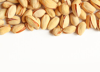 Salty pistachios covering half of the image.Pile of shelled fruit