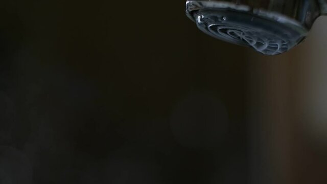 Water flows from the aerator of the tap of the water mixer. Drop formation. Close-up.