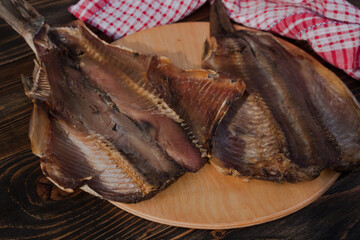 Smoked cut fish on a wooden background. 