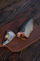 Headless mackerel on a wooden stand, close-up view. 
