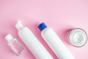 Set of cosmetics for skin care and cleansing on pink background. The concept of purity and body health. Place for text.