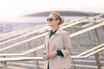 Obraz premium Young beautiful businesswoman with sunglasses, phone, laptop, cup of coffee in the city streets.