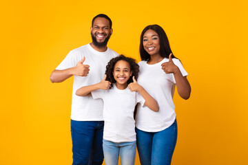 Happy black family gesturing thumbs up and smiling