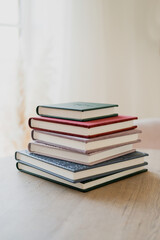 Color modern books diaries in the office on the table. A notebook for teaching school records and events. Photo album for photos. Copy space.