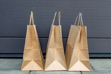 Three craft paper bags over the concrete wall background.
