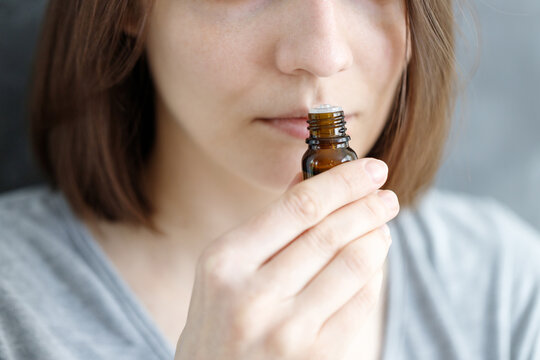 Young And Beautiful Caucasian Women Sniff A Tube Of Aromatic Oil, To Check For Covid-19 Symptoms Or A Female Perfumer Sniffs A New Perfume Fragrance For Women