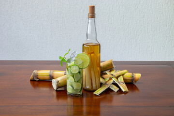 Typical Brazilian caipirinha with cachaça bottle with pieces of sugar cane in sugar cane bark