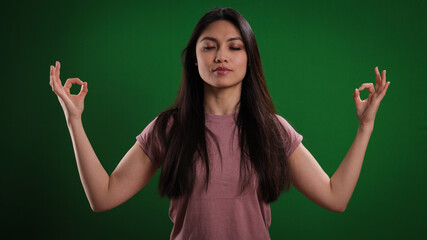 Young woman meditates against a neutral background - studio photography