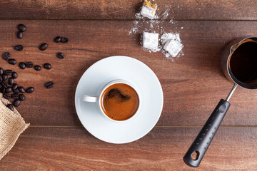 Flat lay top view image showing Traditional Turkish coffee served in classical cups with Turkish delights. A metal coffee pot is in the background.