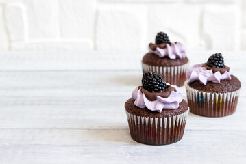 Delicious cupcakes with lavender cream   and blackberries.