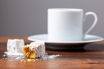 Traditional Turkish coffee served in classical cups with Turkish delights. A metal coffee pot is in the background.