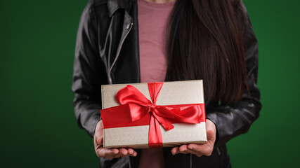 Young woman holding a gift box in her hands - studio photography