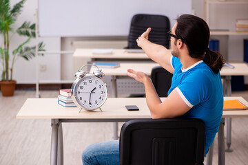 Young male student in time management concept