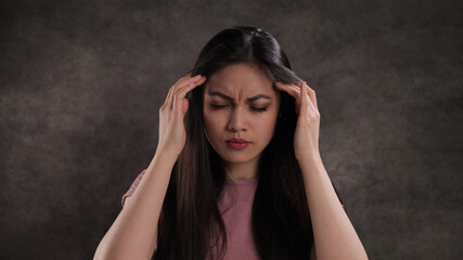 Young woman suffers from headache - studio photography