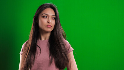Fototapeta premium Young pretty woman in the studio posing against a green background - studio photography