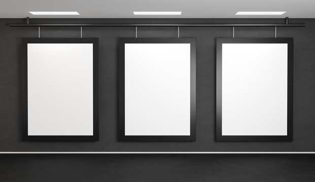 Three images hang on a dark gray concrete wall. Posters template with black frames. 3D rendering mockup for art gallery or cinema.