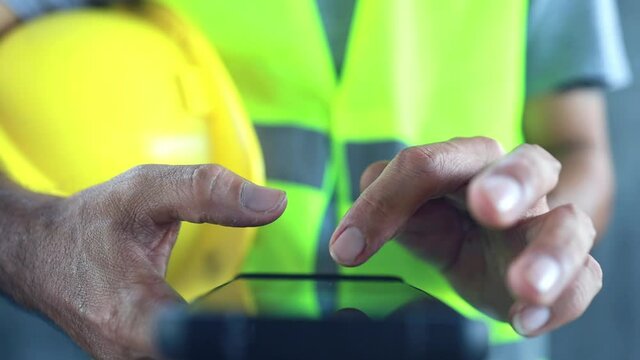 Close up construction worker touch screen on smart phone