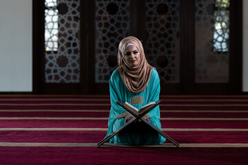 Young Muslim Woman Reading Koran in the Mosque