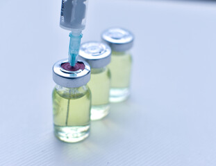 Vial of drugs injection or vaccine with syringe needle on a white background for cure and...