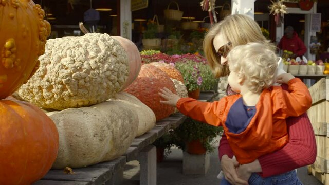 Mother and son selecting pumpkins in farm shop