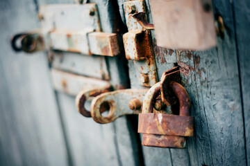 A rusty old lock on a wooden door.
