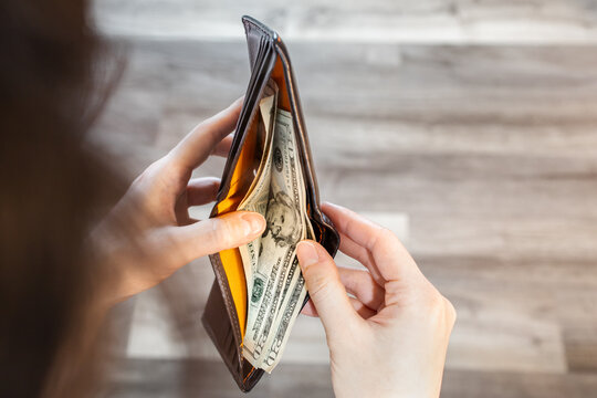 Person open and peeking cash inside wallet, 20 dollar of pocket money for daily life spending. People looking down for debt payment. American currency banknotes, worldwide business financial concept.
