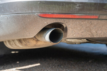 Exhaust pipe of a car close-up. Environmental pollution due to transportation with a dirty auto....