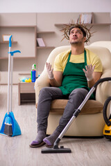 Young male contractor wearing prickly wreath on head cleaning th