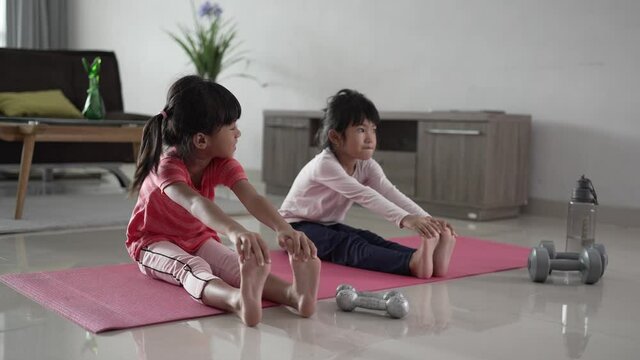 portrait of asian happy two little girl exercising at home