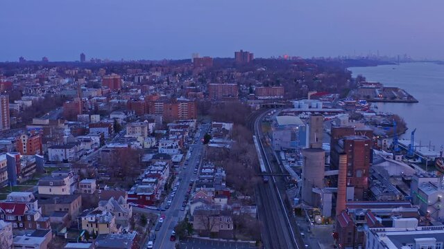 Train crossing Yonkers city at evening. Aerial forward