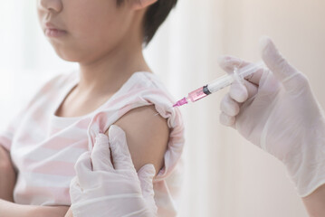 Asian child receiving injection or vaccine