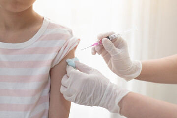 Asian child receiving injection or vaccine