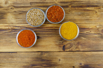 Set of different aromatic spices on wooden table. Top view