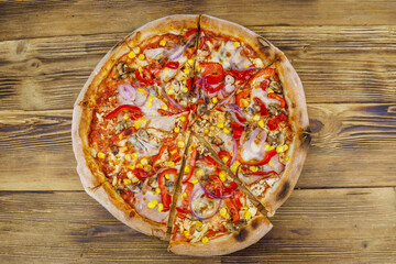 Delicious fresh pizza on a wooden table. Top view