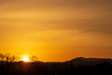 山に沈む夕日　夕焼け　太陽　空　木のシルエット